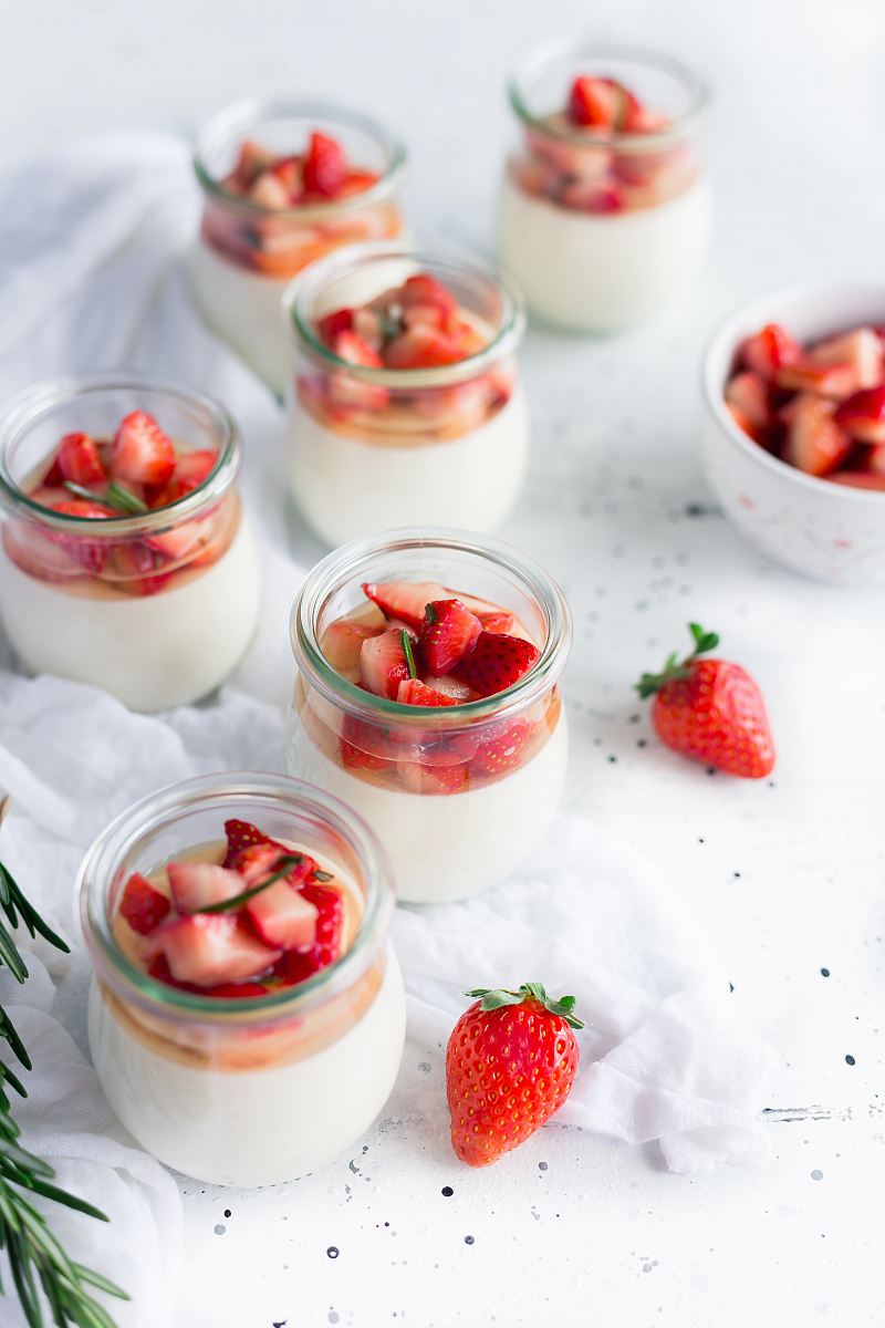 sliced strawberries in clear glass jar with cream