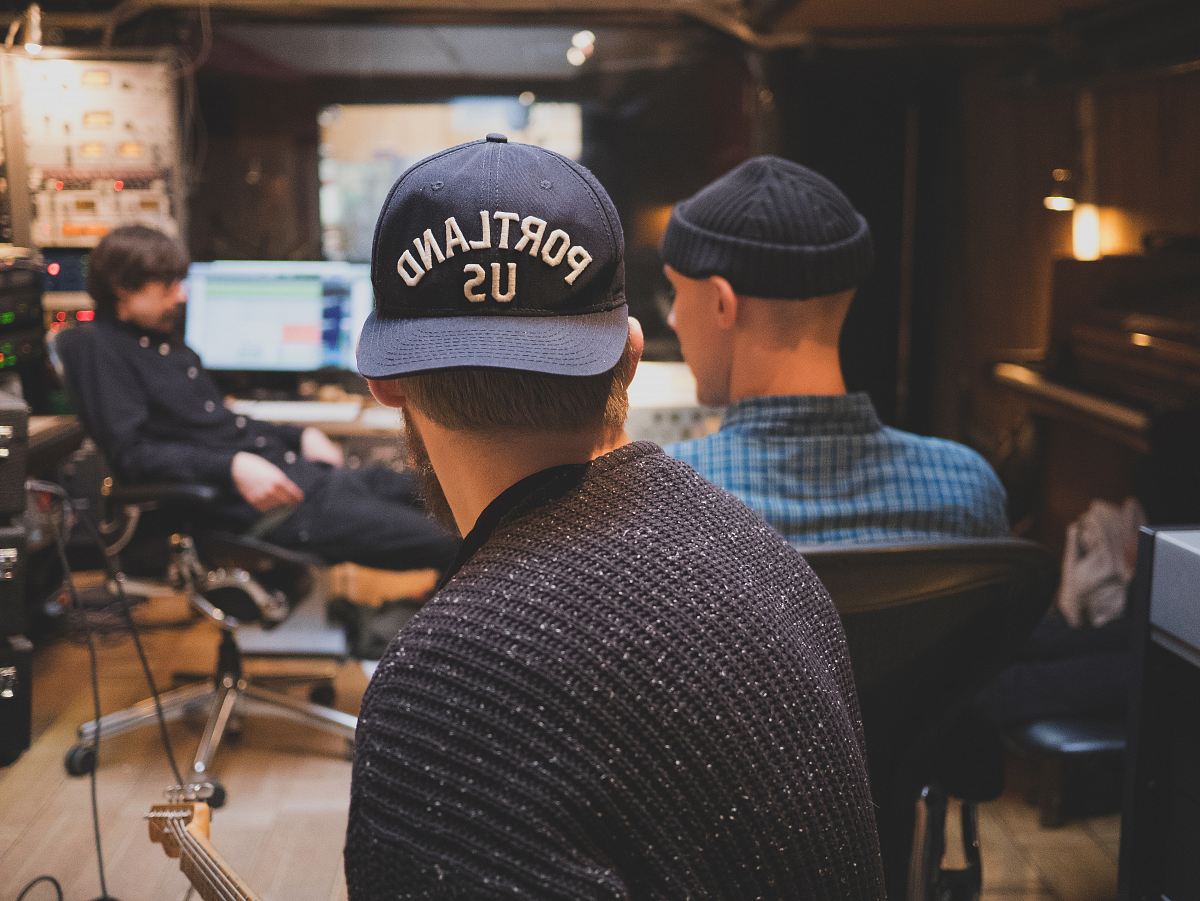 three men inside music studio