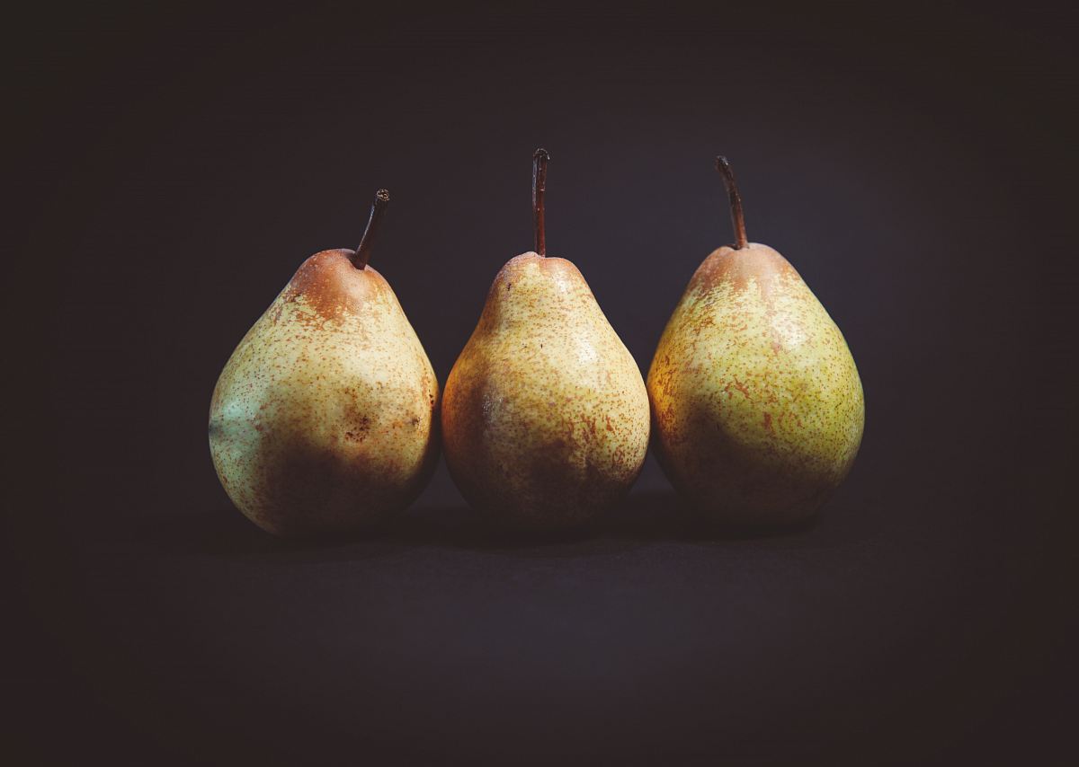 three pears on black surface