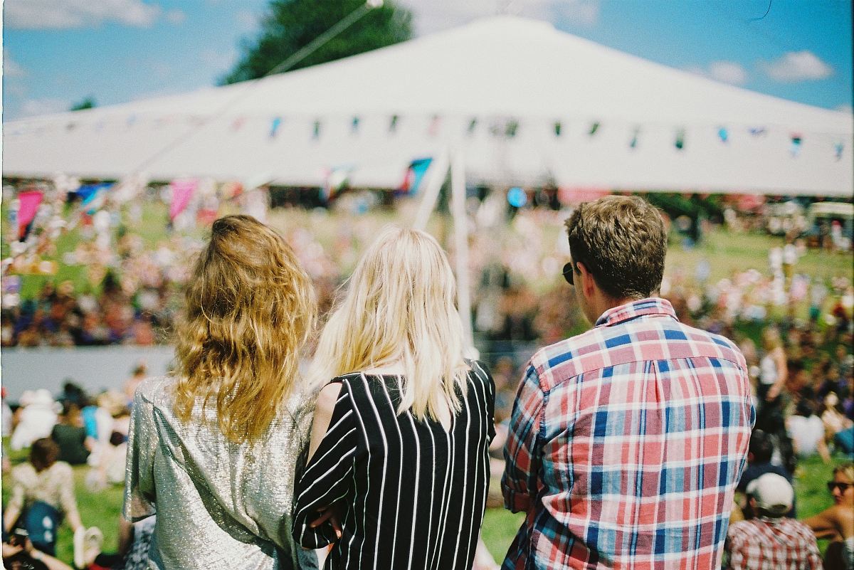three person's standing front of field