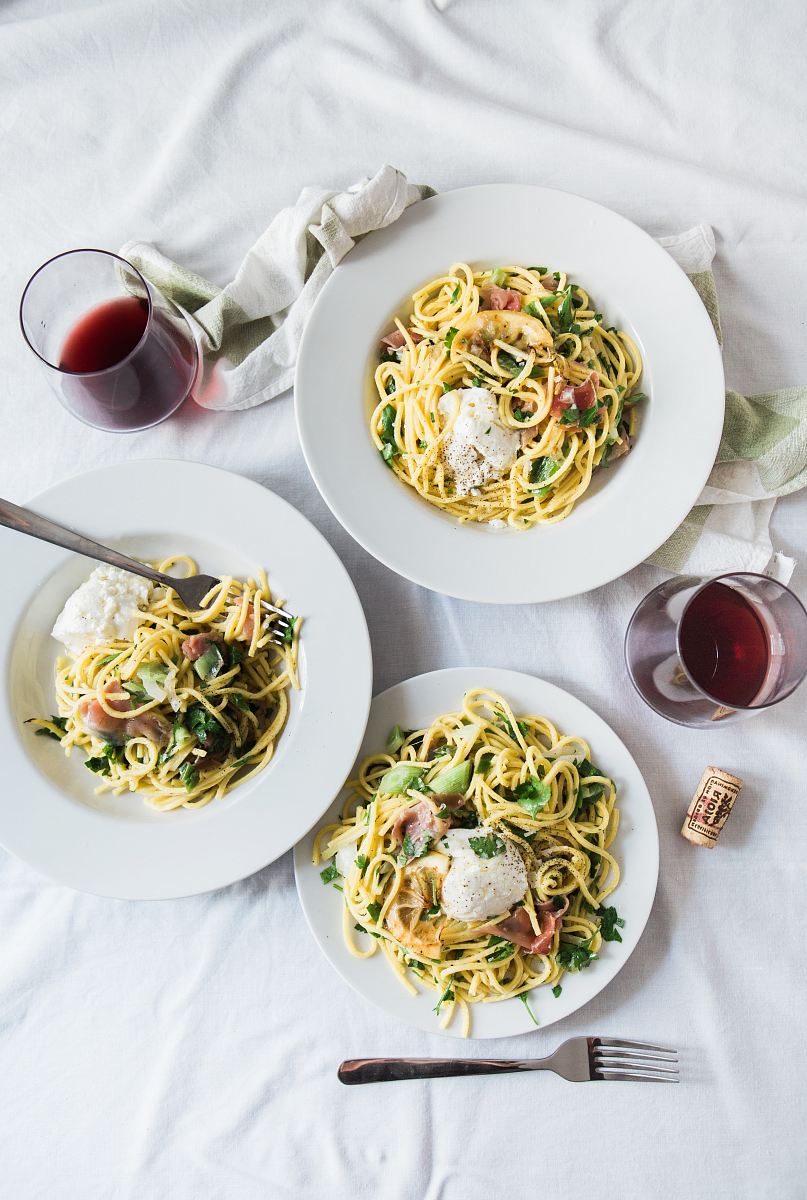 three round white plates with pasta near two glass cuups
