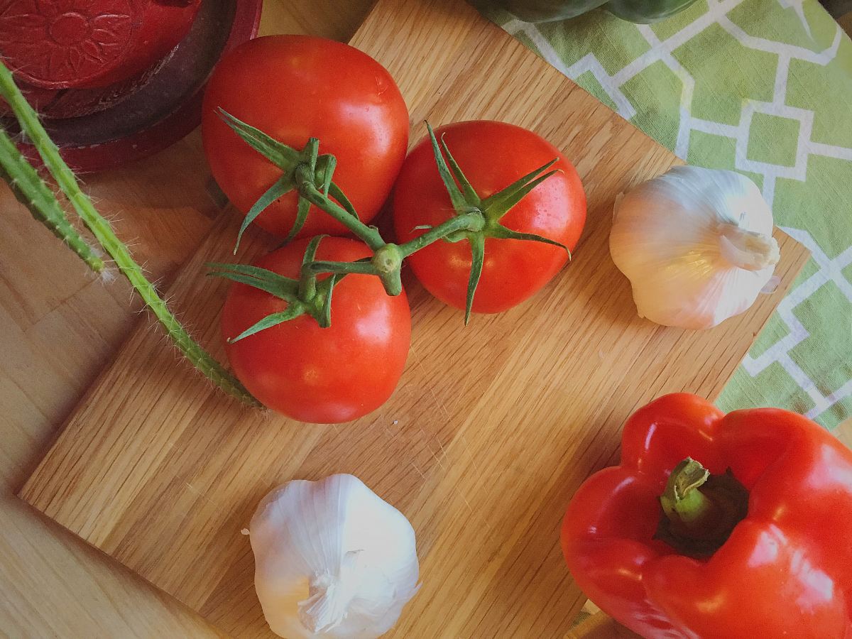 three tomatoes beside garlic