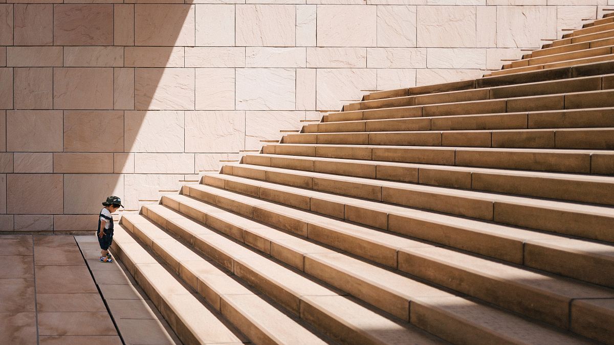 toddler's standing in front of beige concrete stair