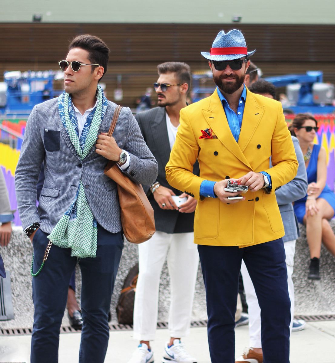 two man wearing yellow and grey suit jacket standing close together