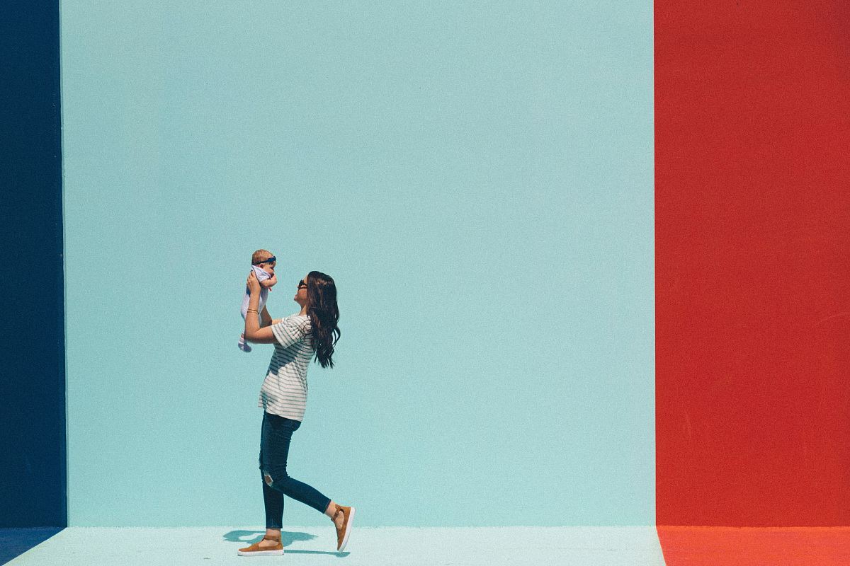 woman carrying baby while walking