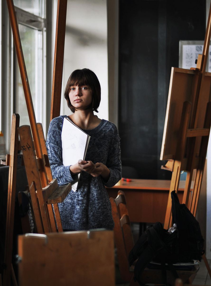 woman holding art book inside art studio