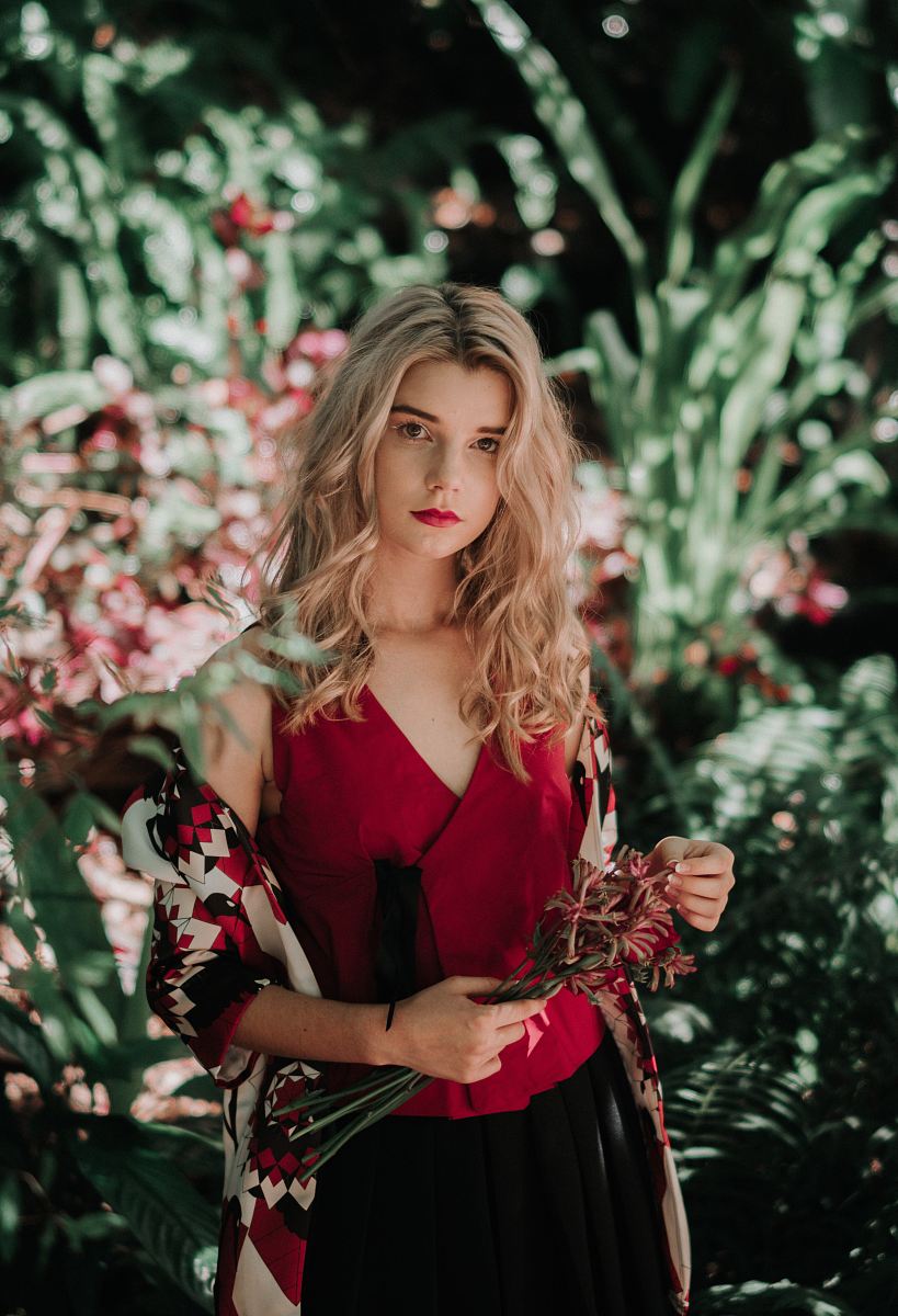 woman holding flowers in front of the garden