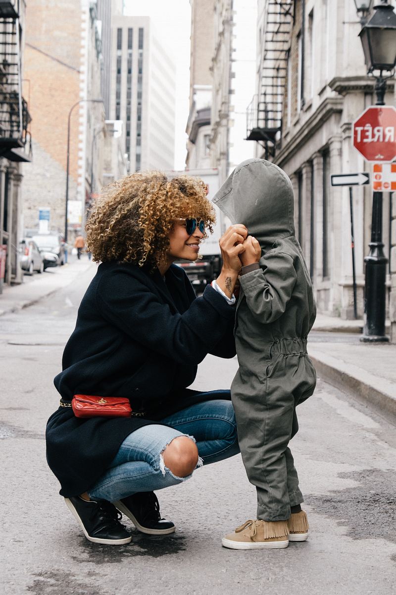 woman holding kid at the street