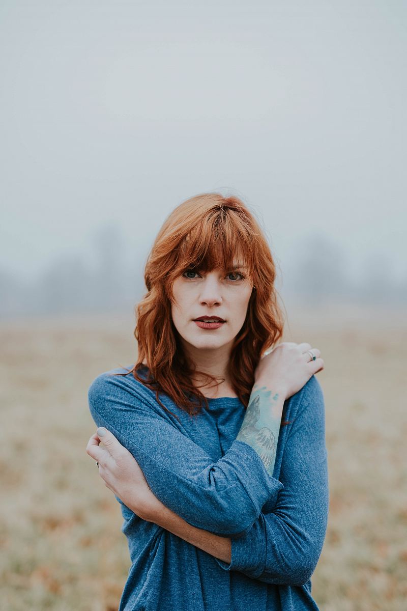 woman in blue raglan shirt shallow focus photography