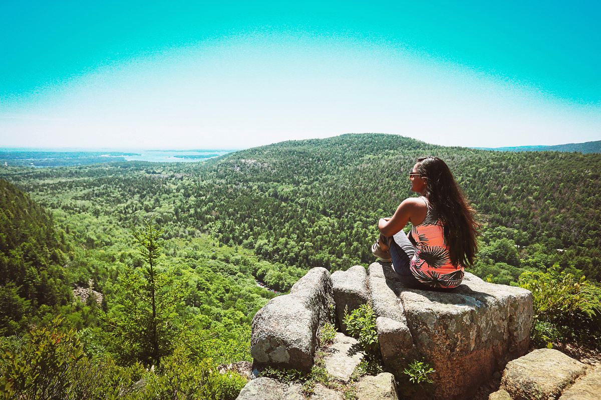 woman in orange and black sleeveless top on rock