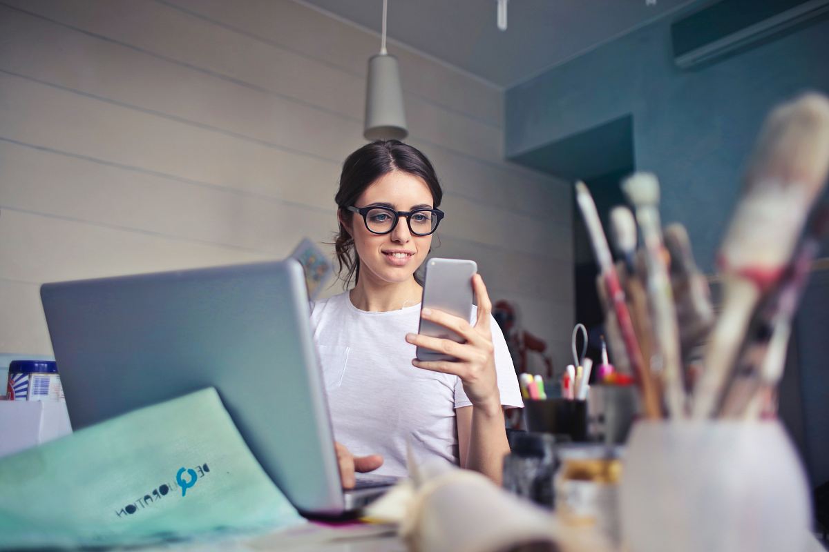 woman in white shirt using smartphone