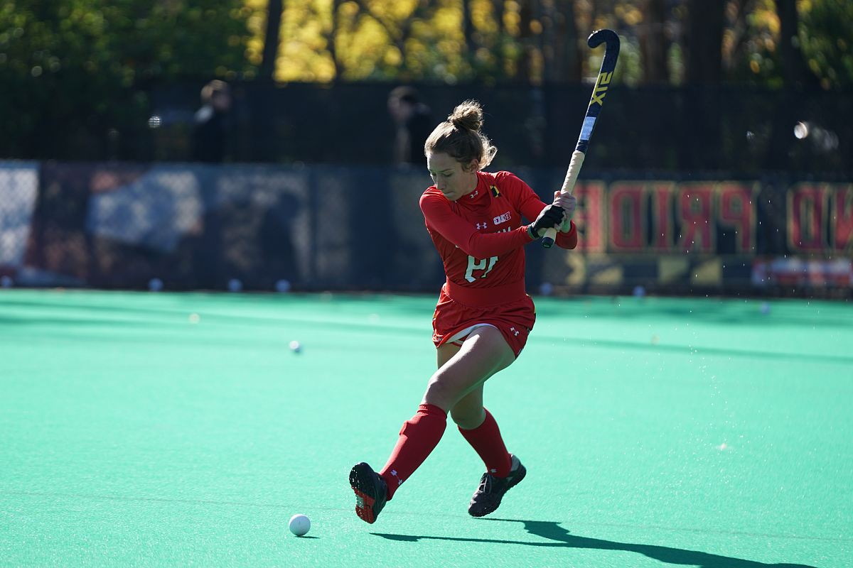 woman playing hockey on fields during daytime