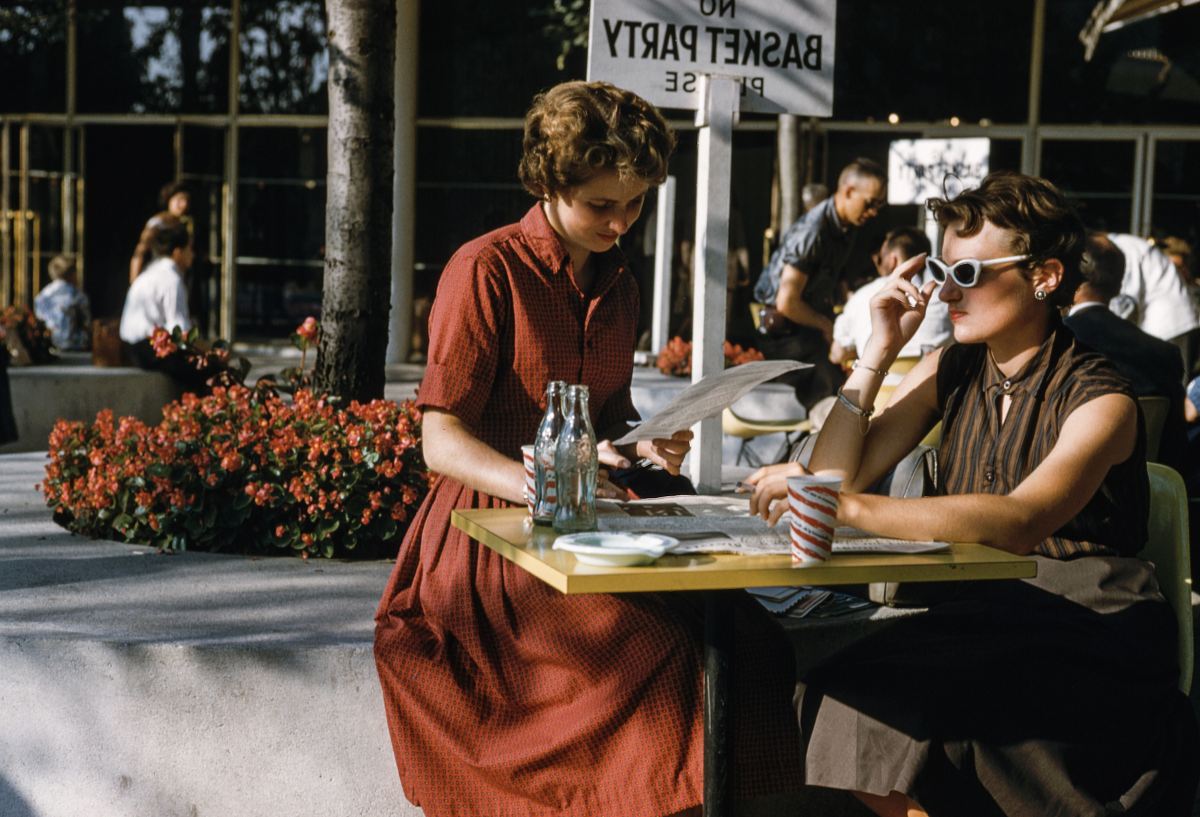 woman sitting in front of table with two empty glass bottles