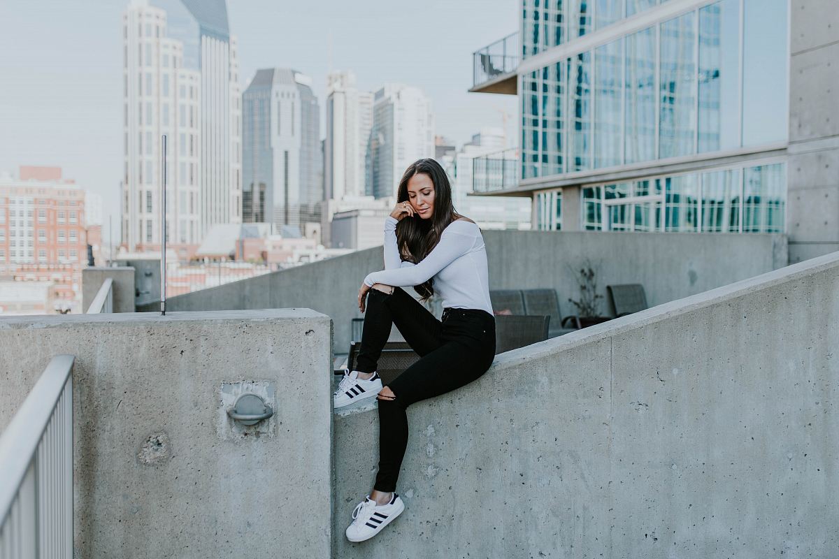 woman sitting on concrete building