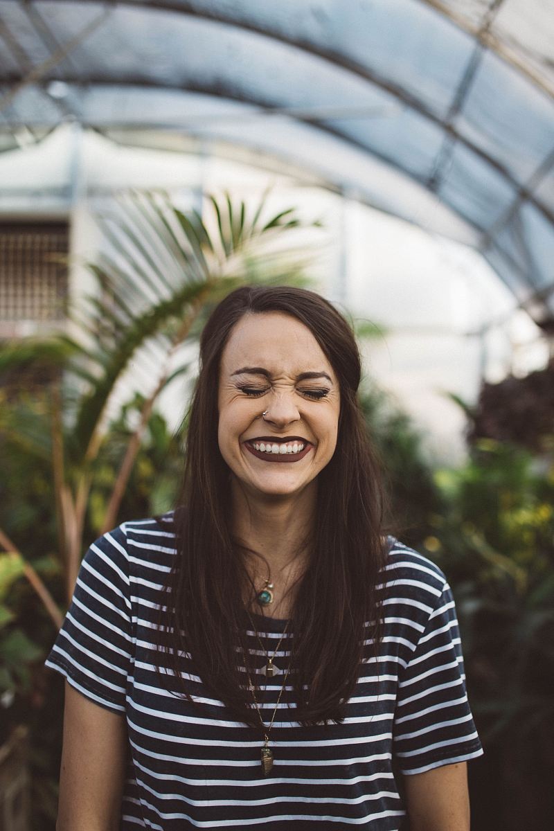 woman smiling while standing in garden