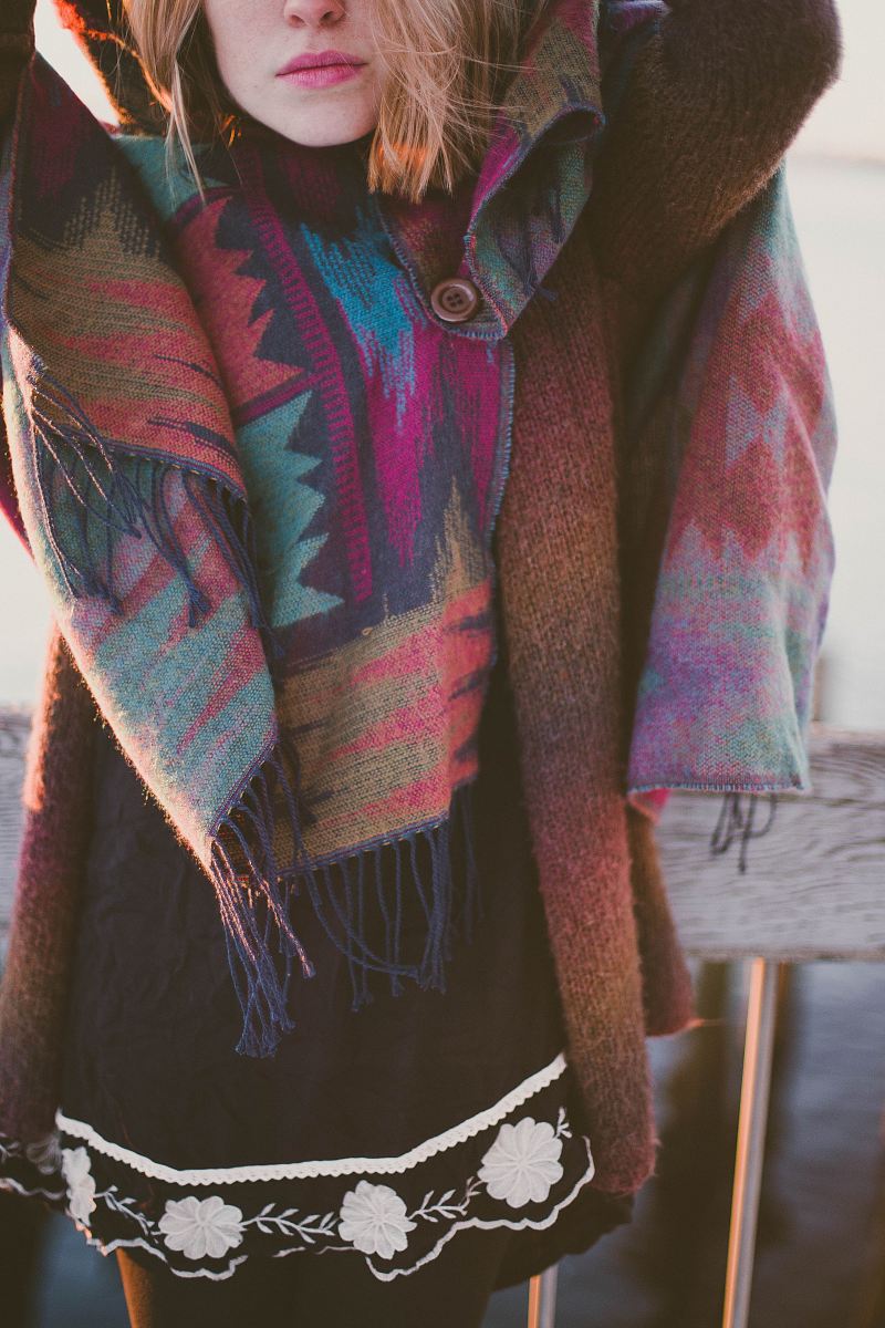 woman wearing brown knitted cardigan standing beside fence