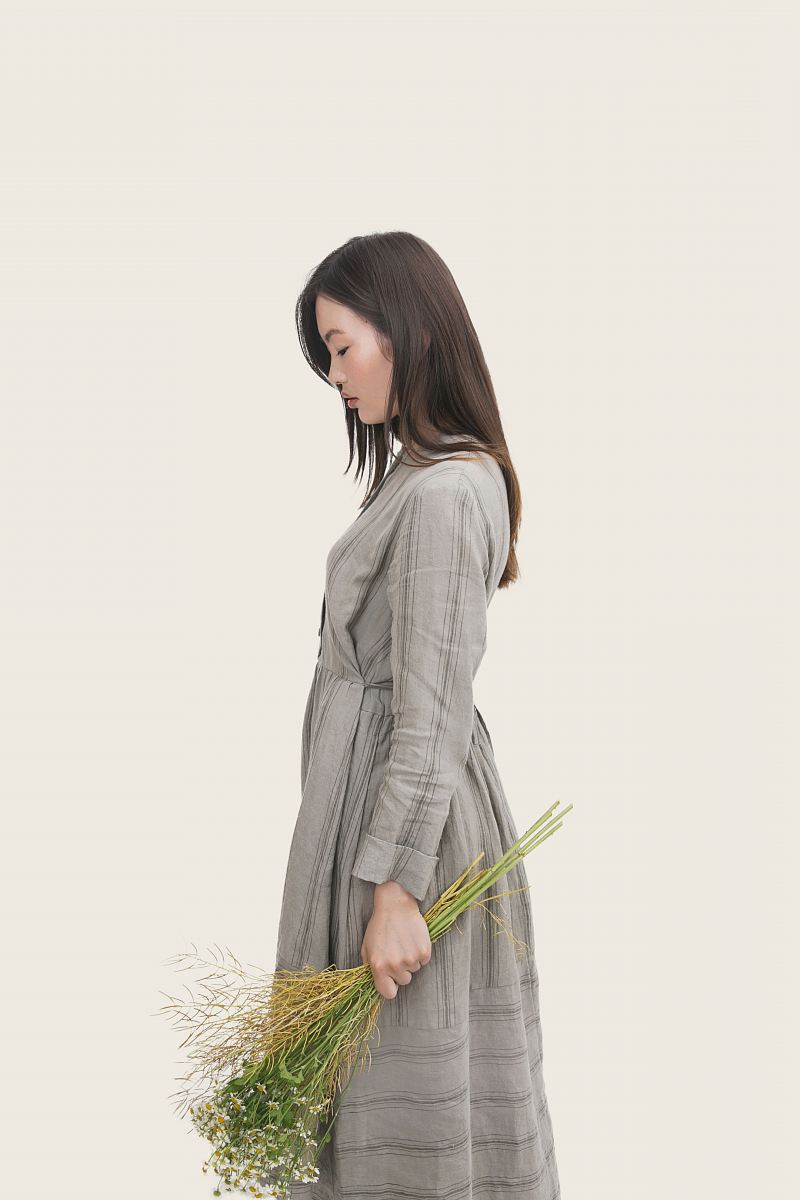 woman wearing grey dress holding flowers