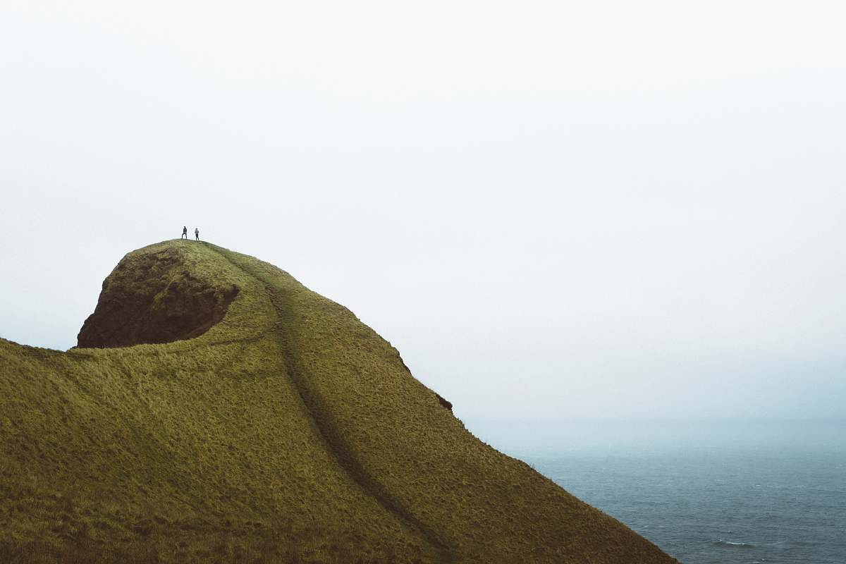  two persons on hilltop during daytime 