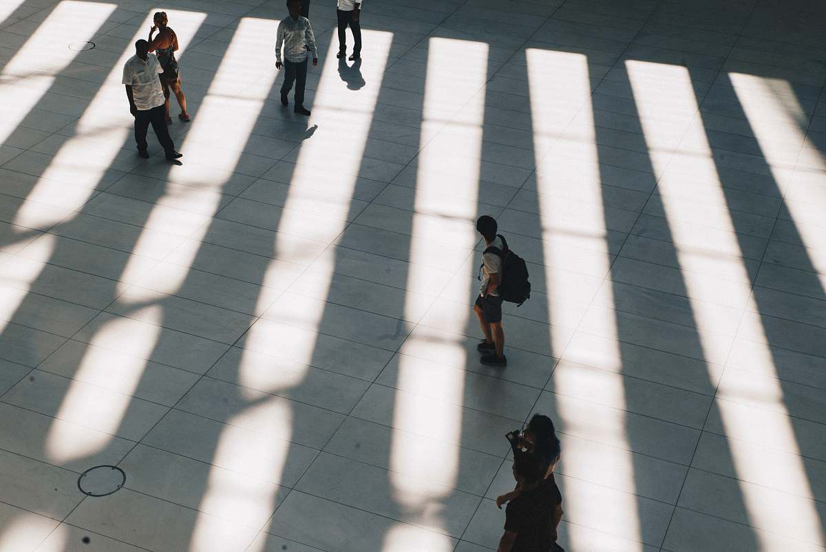 road aerial photo of people walking on gray concrete pathway during daytime tarmac