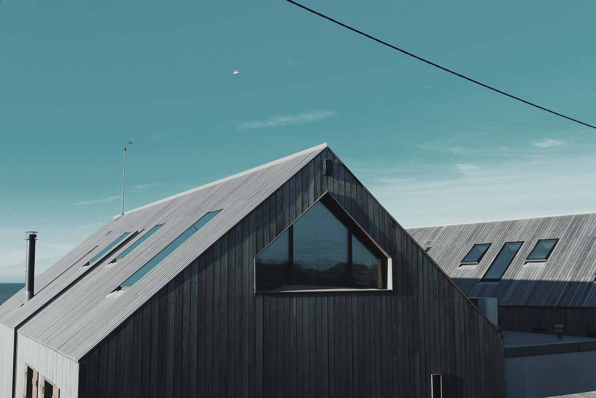 architecture gray wooden house near body of water window