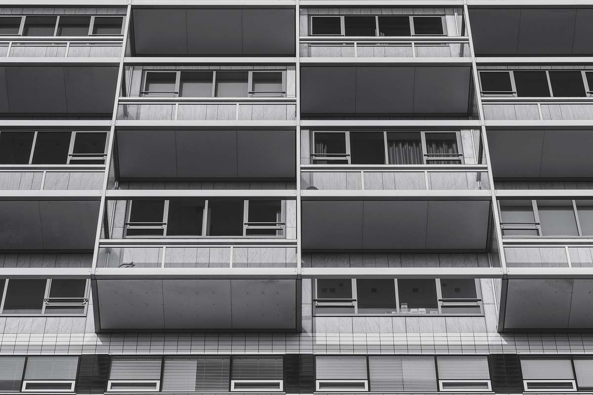 black-and-white worm's eye view of apartment complex balcony