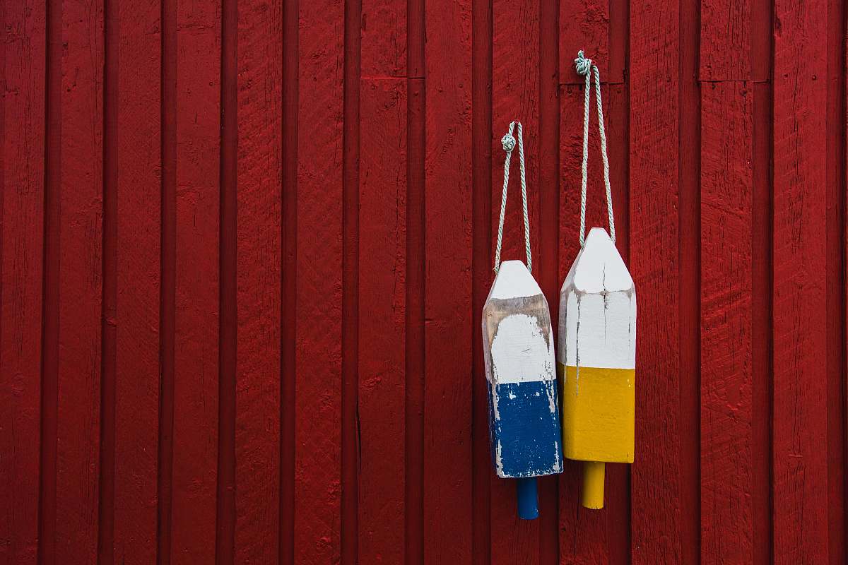 fence two yellow and blue hanging decors behind red wall red