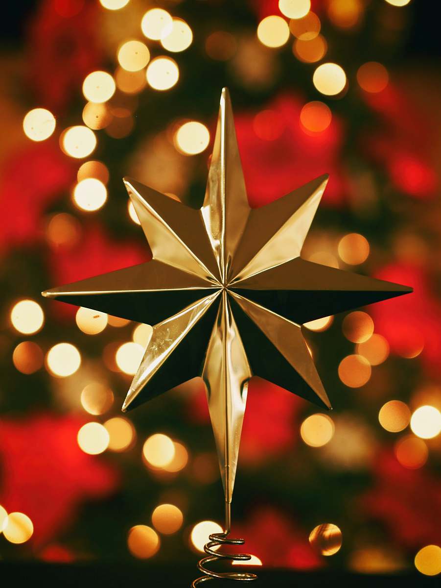 holiday bokeh photography of gold star tree topper star