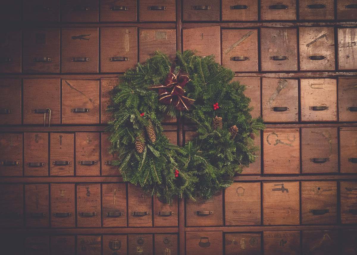 tree green and brown pinecone Christmas wreath on wooden drawers holiday
