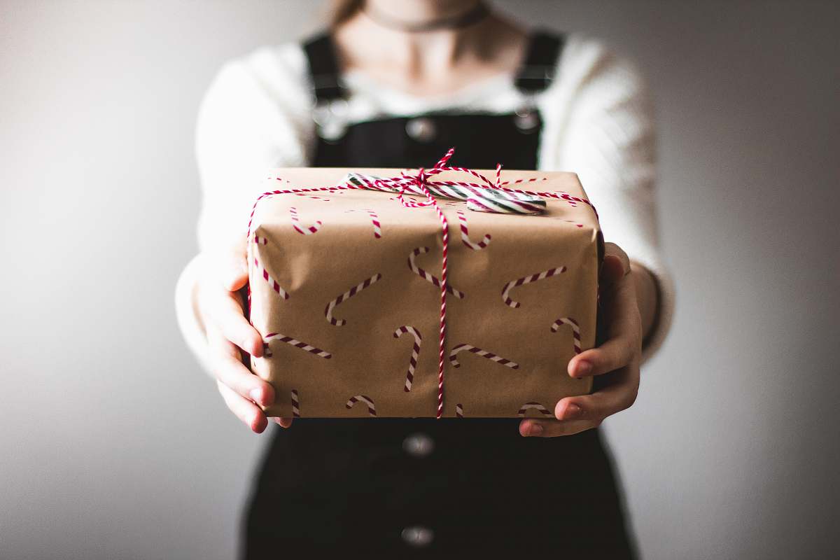 holiday person showing brown gift box gift