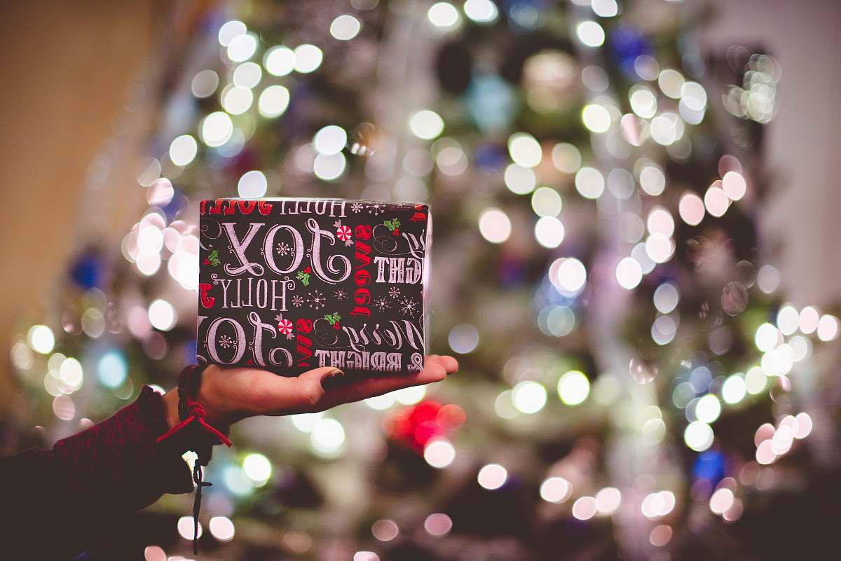 holiday selective focus photography of gift box on person's palm joy