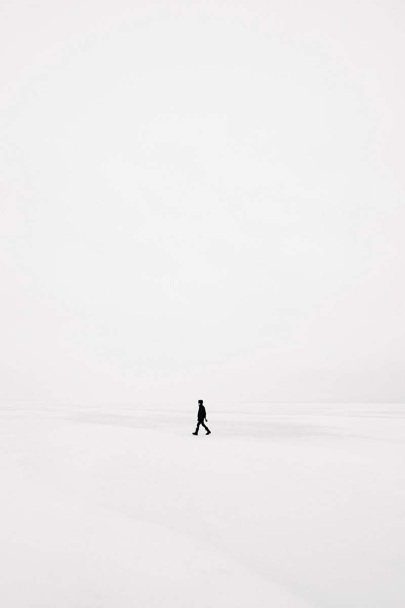 white person walking on snowfield black-and-white