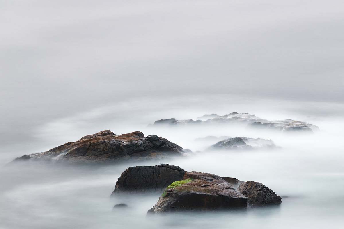 grey time lapse photography of water near island mountain