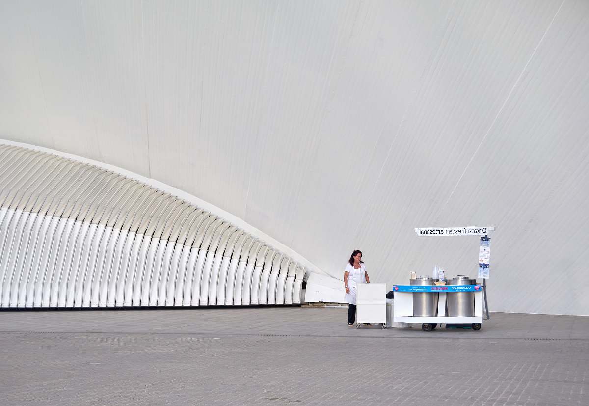 fresh woman wearing white dress and black pants near stall architecture