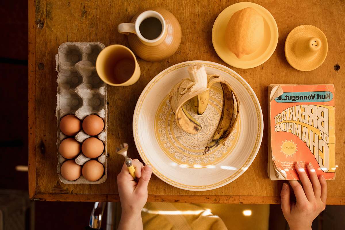 food plate with banana and tray of eggs on table meal