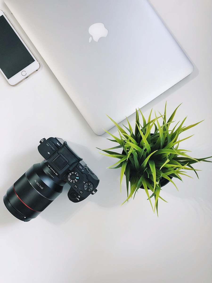 binoculars silver MacBook near black Sony DSLR camera electronics