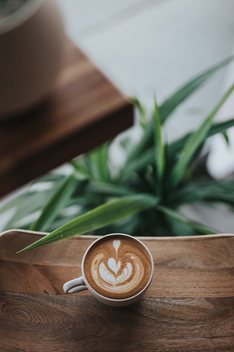 wooden white ceramic coffee mug with coffee on table coffee table