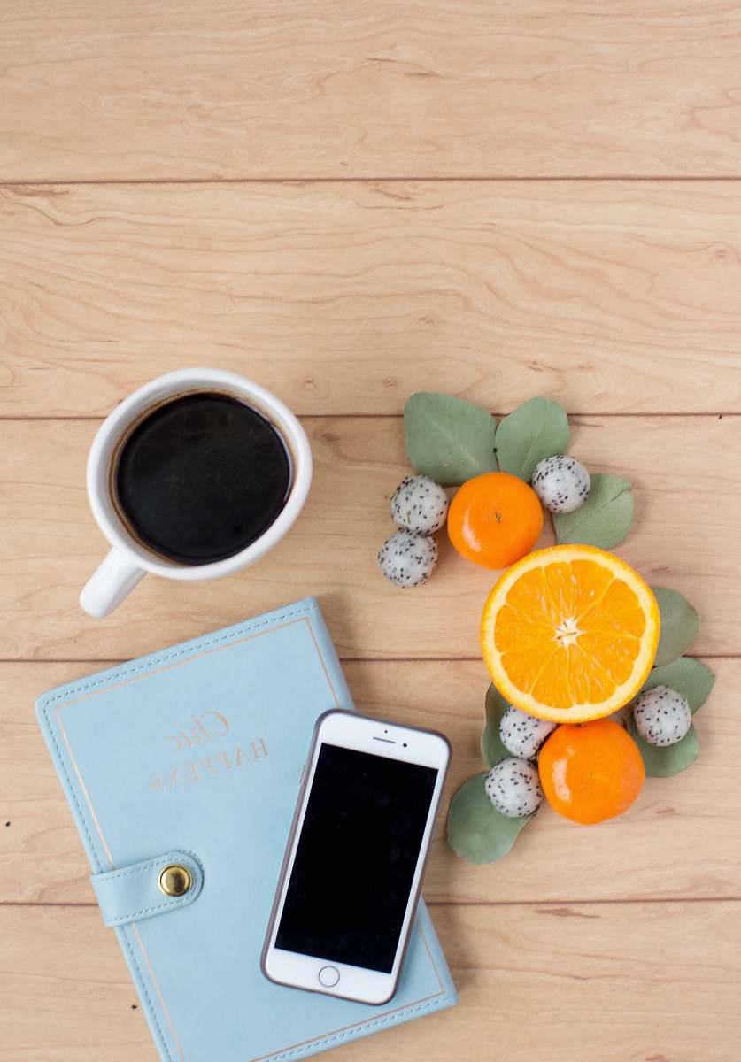 food silver iPhone on book near coffee fruit
