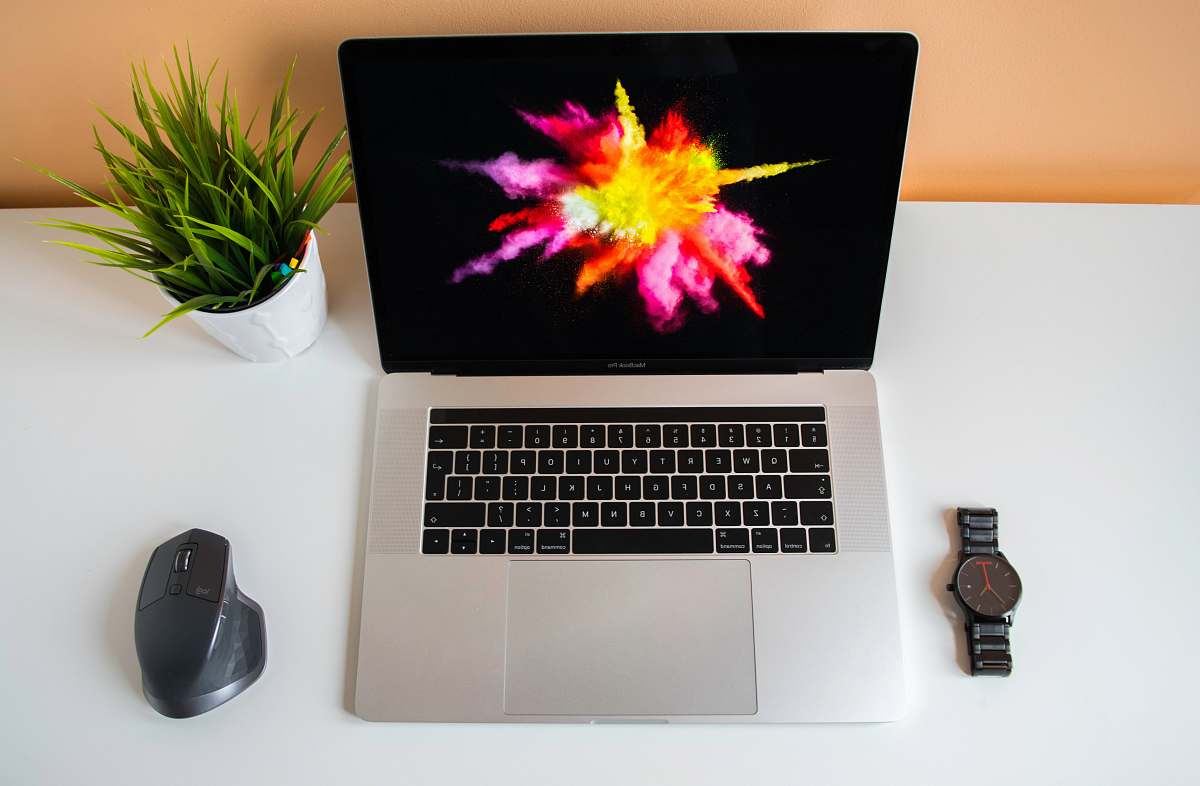 mouse flat lay photography of MacBook Pro in between mouse and watch lcd screen