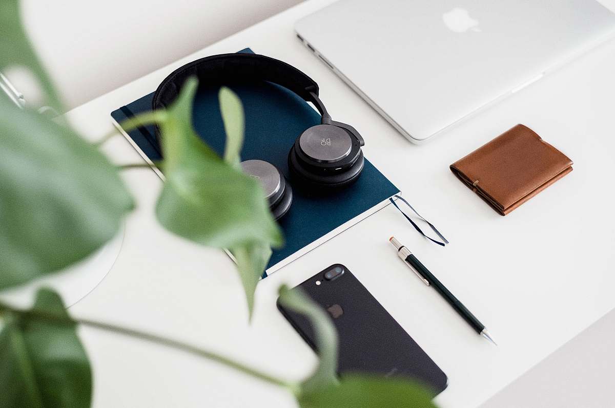 tabletop black and gray headphones on blue book desktop