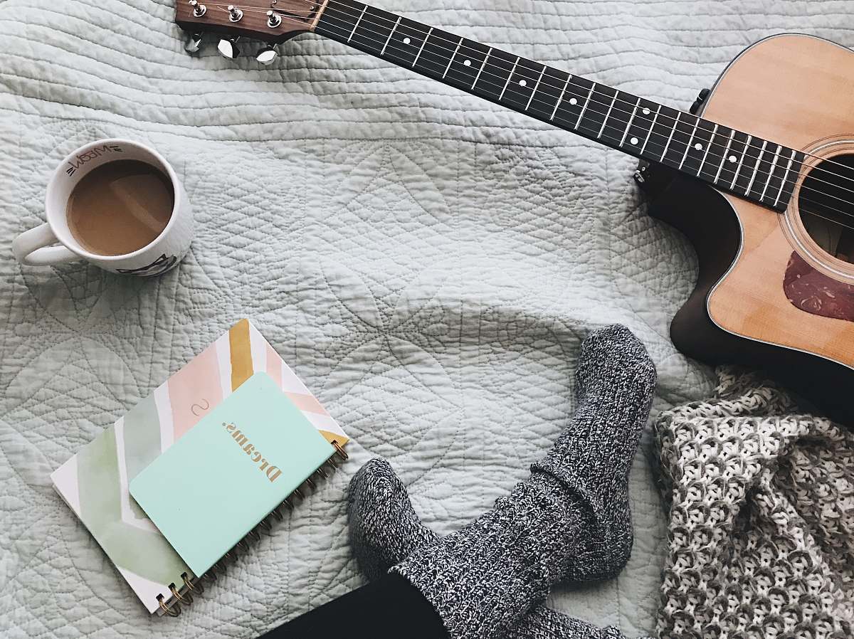 guitar person wearing gray socks near acoustic guitar music