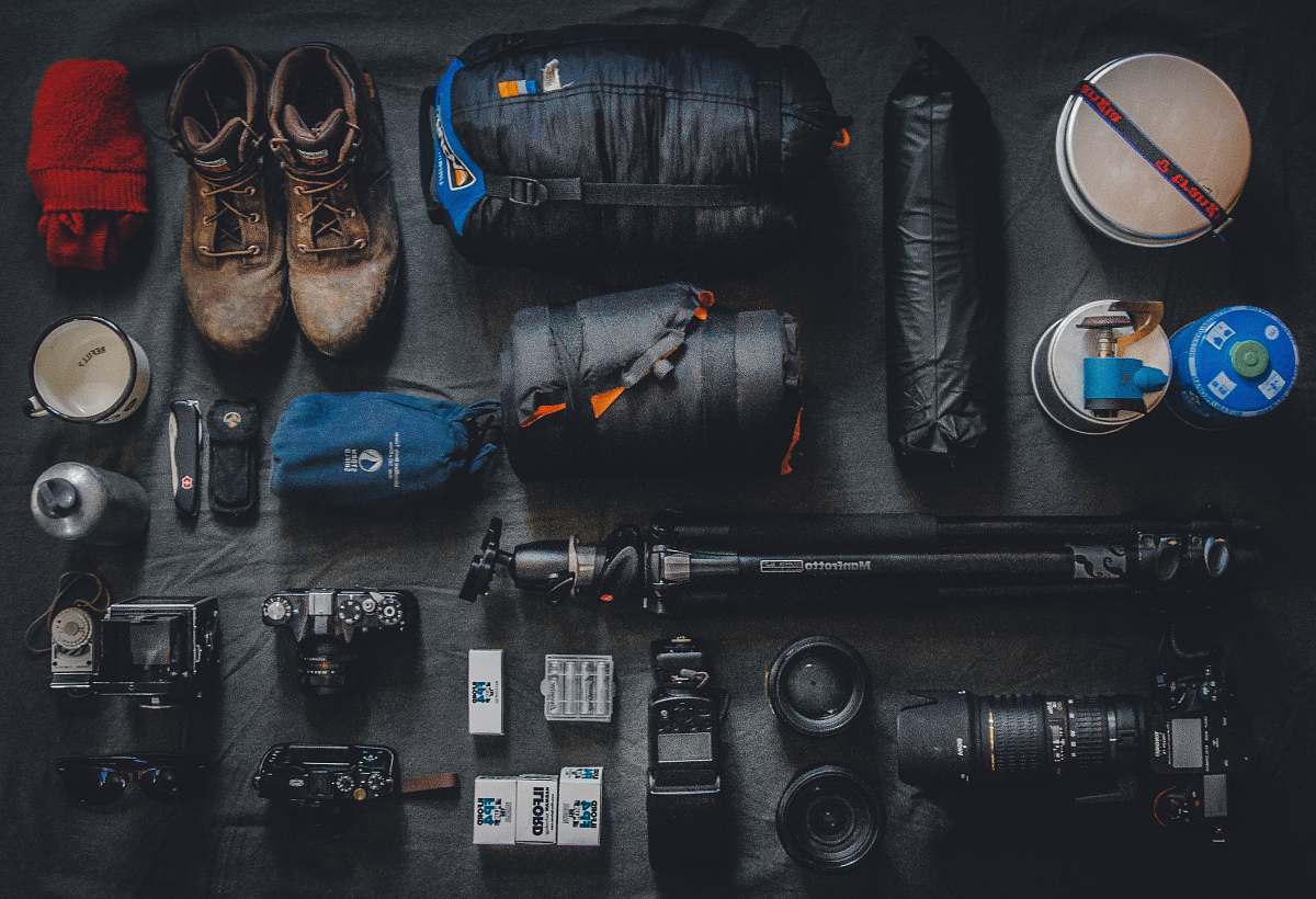 camping photo of assorted cameras and bags explore