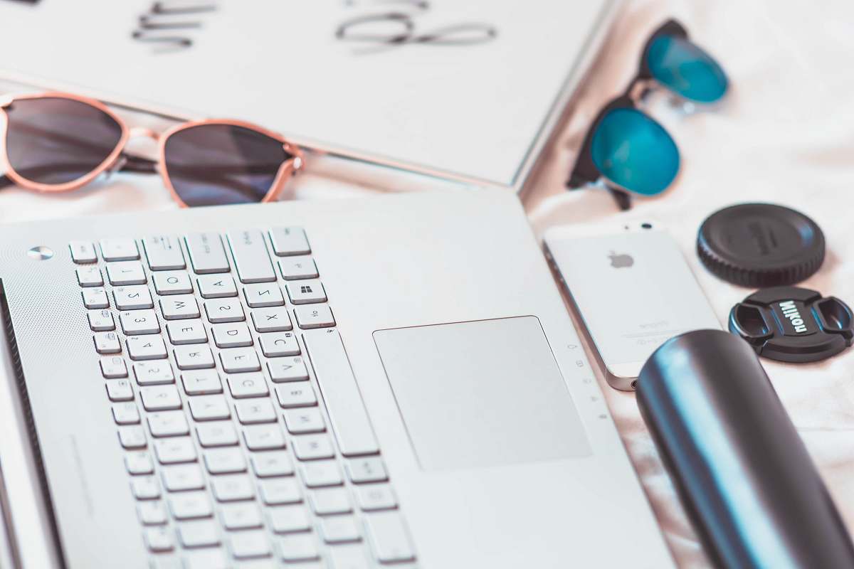 windows laptop, iPhone, and sunglasses on table desktop