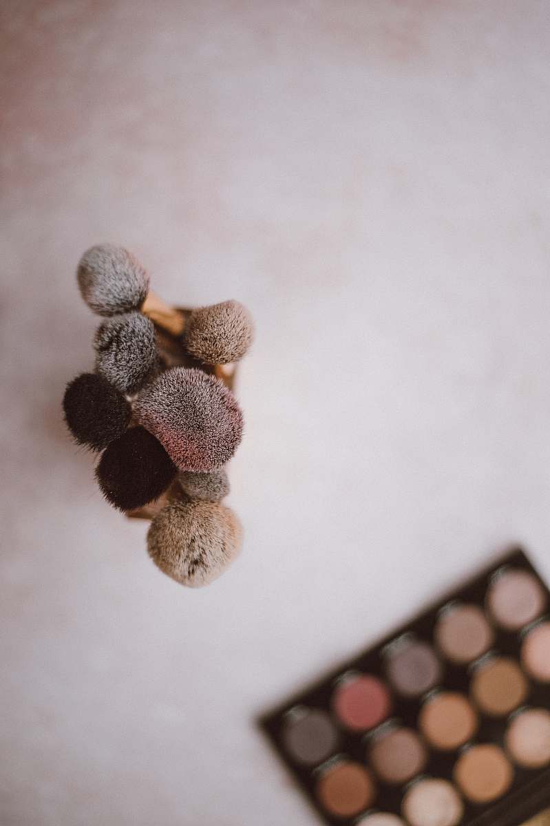 grey makeup brush beside palette produce