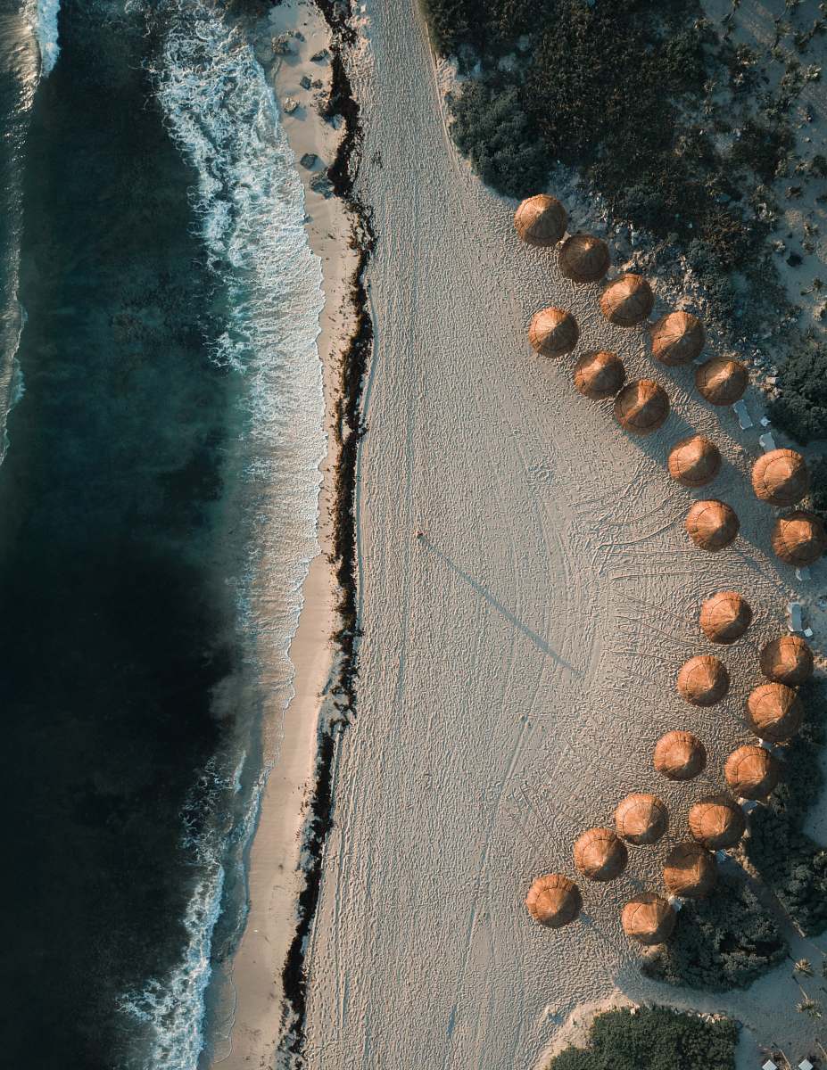 landscape aerial photography of brown cottages on seashore at daytime drone view