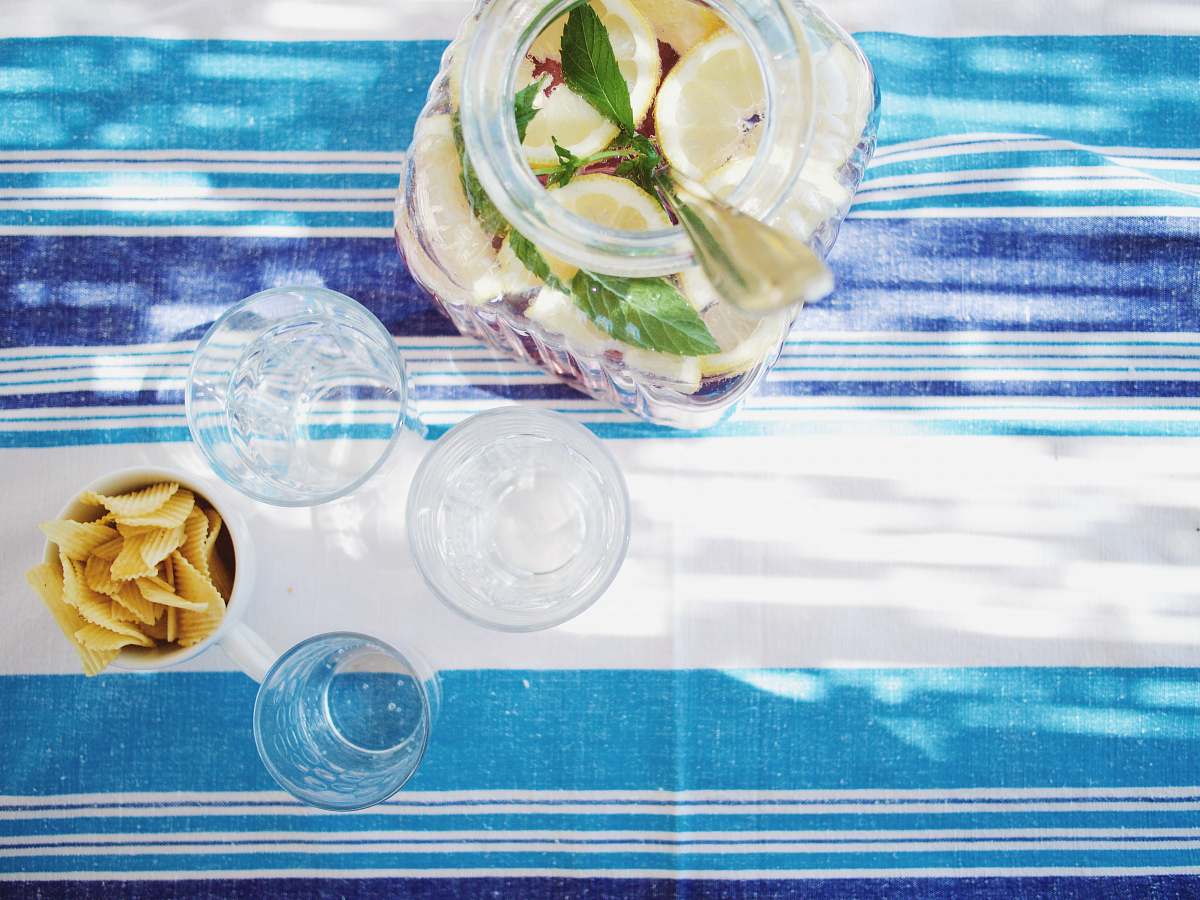 tablecloth lime juice bottle beside shot glasses on table glass