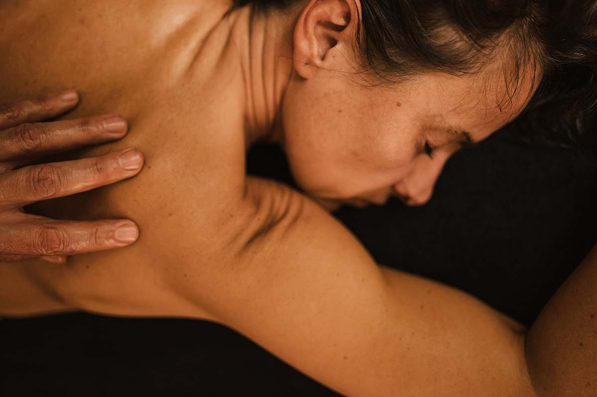 person topless woman covering her face arm