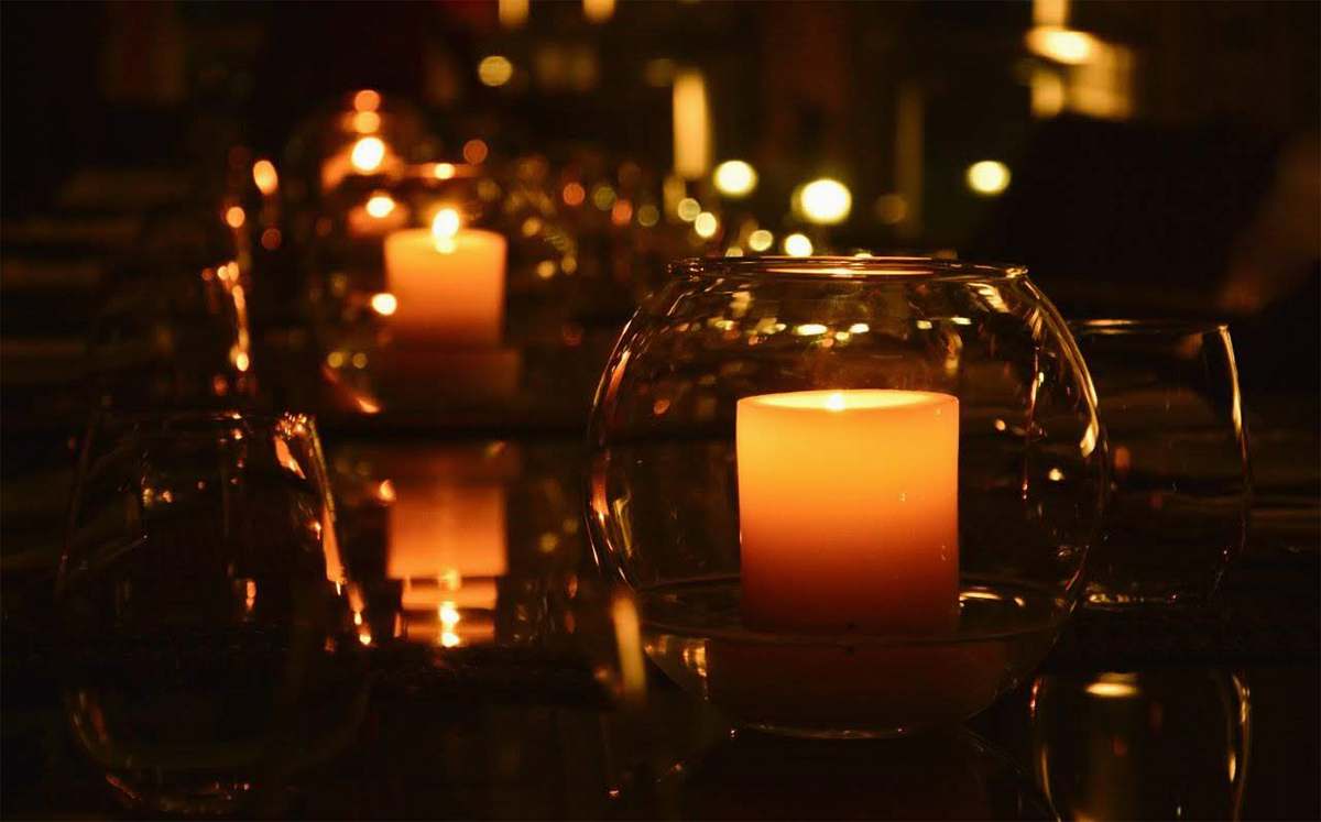 lighting lit pillar candle in clear glass holder fire