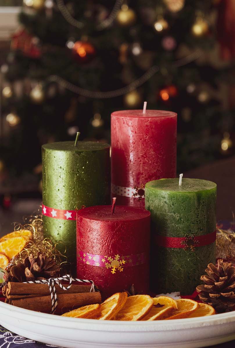 fire red and green candles on white tray plant