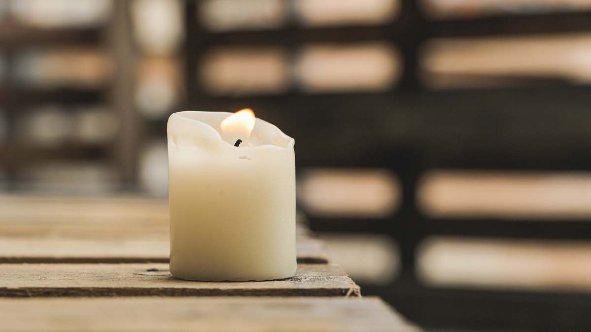 light selective focus photography of white pillar canle table top