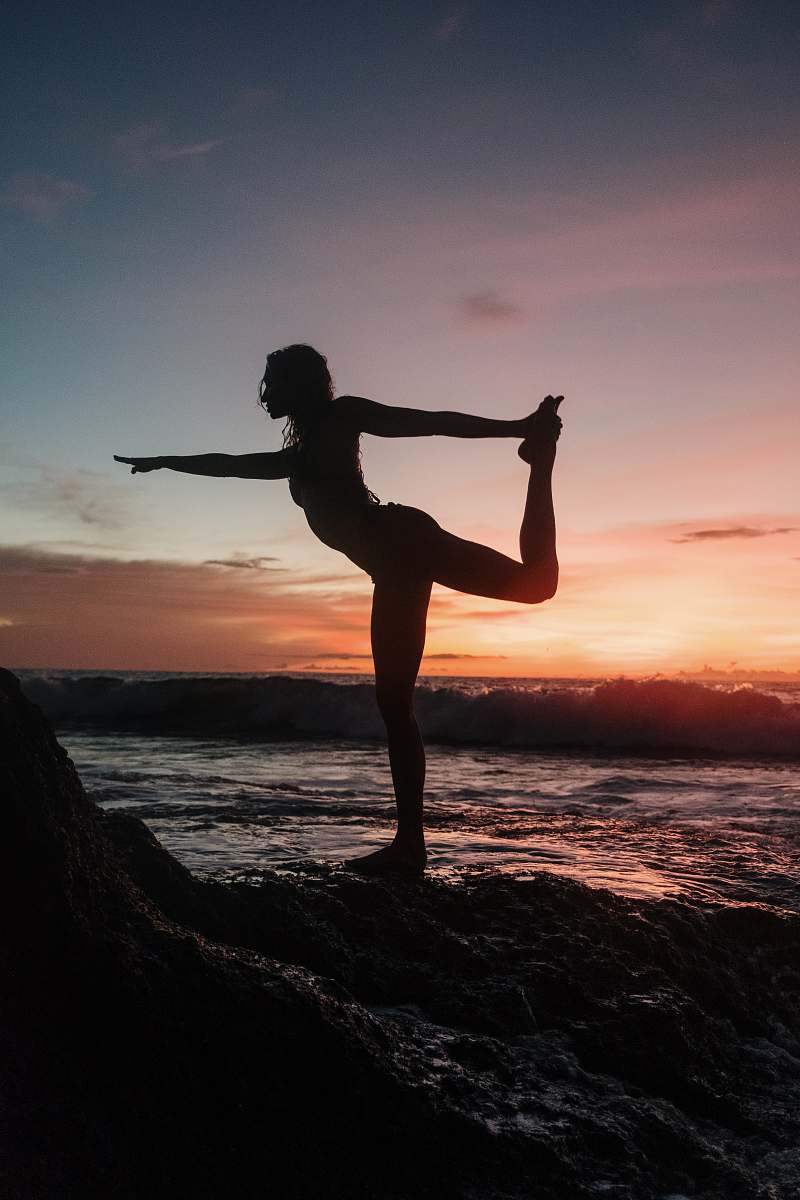  silhouette of woman standing on rock during sunset 